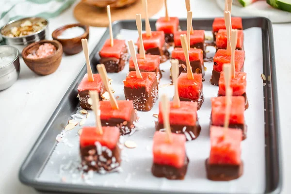 Çikolata ve sprinked deniz tuzu ve badem ile daldırma karpuz mezeler hazırlanıyor.