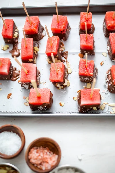 Çikolata ve sprinked deniz tuzu ve badem ile daldırma karpuz mezeler hazırlanıyor.