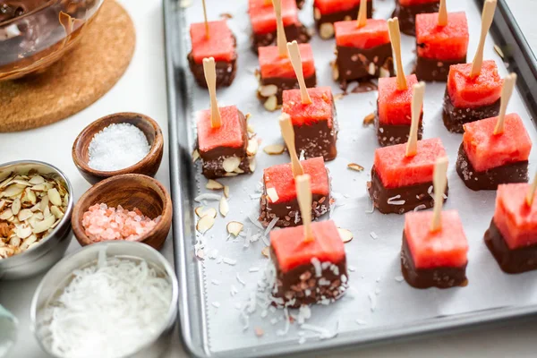 Çikolata ve sprinked deniz tuzu ve badem ile daldırma karpuz mezeler hazırlanıyor.
