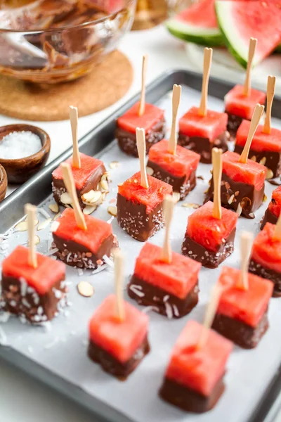 Çikolata ve sprinked deniz tuzu ve badem ile daldırma karpuz mezeler hazırlanıyor.