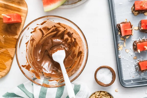 Çikolata ve sprinked deniz tuzu ve badem ile daldırma karpuz mezeler hazırlanıyor.