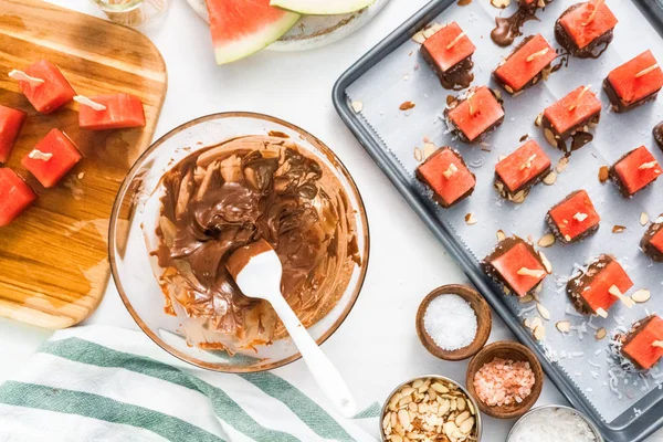 Çikolata ve sprinked deniz tuzu ve badem ile daldırma karpuz mezeler hazırlanıyor.