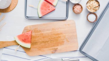 Adım adım. Ahşap pop sopa karpuz buz yapmak için karpuz ücret kama kayar açılır.