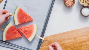 Adım adım. Ahşap pop sopa karpuz buz yapmak için karpuz ücret kama kayar açılır.