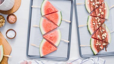 Adım adım. Karpuz dilimleri sac pişirme üzerinde tahta bir sopa üzerinde.