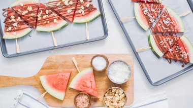 Adım adım. Karpuz dilimleri sac pişirme üzerinde tahta bir sopa üzerinde.