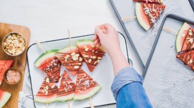 Adım adım. Karpuz dilimleri çikolata ve deniz ile süslenmiş Tepsi hizmet veren demir çubuk üzerinde tuz.