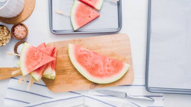 Adım adım. Karpuz dilimleri sac pişirme üzerinde tahta bir sopa üzerinde.