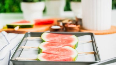 Adım adım. Karpuz dilimleri sac pişirme üzerinde tahta bir sopa üzerinde.