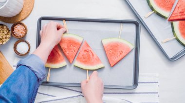 Adım adım. Karpuz dilimleri sac pişirme üzerinde tahta bir sopa üzerinde.