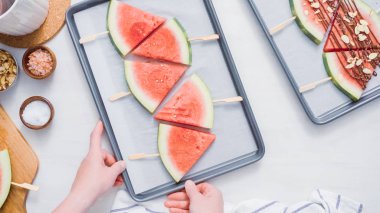 Adım adım. Karpuz dilimleri sac pişirme üzerinde tahta bir sopa üzerinde.