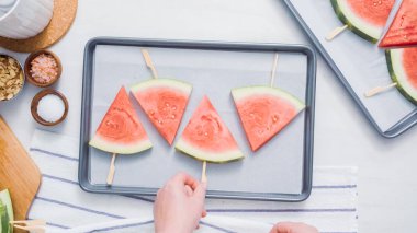 Adım adım. Karpuz dilimleri sac pişirme üzerinde tahta bir sopa üzerinde.