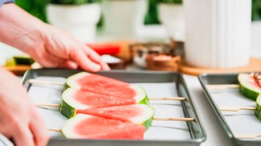 Adım adım. Karpuz dilimleri sac pişirme üzerinde tahta bir sopa üzerinde.