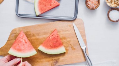 Adım adım. Ahşap pop sopa karpuz buz yapmak için karpuz ücret kama kayar açılır.