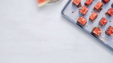 Karpuz küpler eritilmiş çikolata daldırma ve deniz tuzu ve badem ile süsleme.