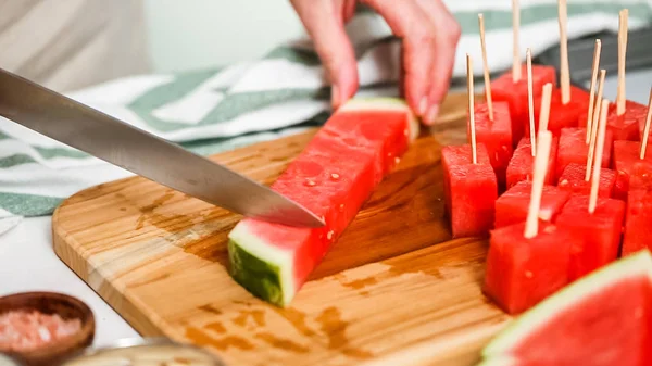 Çikolata kaplı karpuz hazırlanması için küpler halinde karpuz Dilimleme ısırıkları.