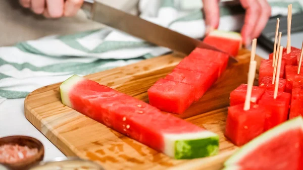 Çikolata kaplı karpuz hazırlanması için küpler halinde karpuz Dilimleme ısırıkları.