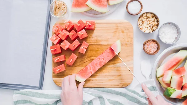 Çikolata kaplı karpuz hazırlanması için küpler halinde karpuz Dilimleme ısırıkları.