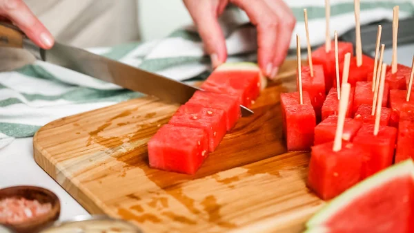 Çikolata kaplı karpuz hazırlanması için küpler halinde karpuz Dilimleme ısırıkları.