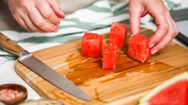 Çikolata kaplı karpuz hazırlanması için küpler halinde karpuz Dilimleme ısırıkları.