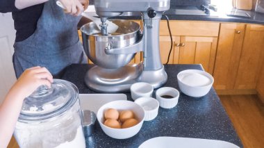 Adım adım. Anne ve kızı mutfakta şekerli kurabiye pişirme.