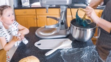 Adım adım. Anne ve kızı mutfakta şekerli kurabiye pişirme.