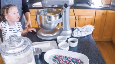 Adım adım. Anne ve kızı mutfakta şekerli kurabiye pişirme.