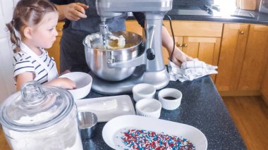 Adım adım. Anne ve kızı mutfakta şekerli kurabiye pişirme.