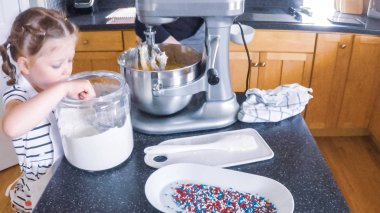 Adım adım. Anne ve kızı mutfakta şekerli kurabiye pişirme.