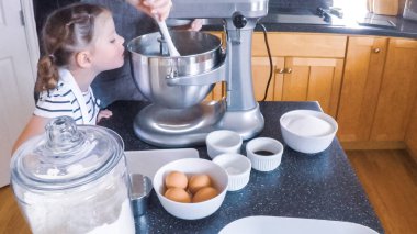 Adım adım. Anne ve kızı mutfakta şekerli kurabiye pişirme.