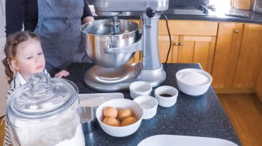 Adım adım. Anne ve kızı mutfakta şekerli kurabiye pişirme.