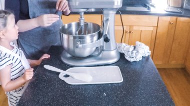 Adım adım. Anne ve kızı mutfakta şekerli kurabiye pişirme.