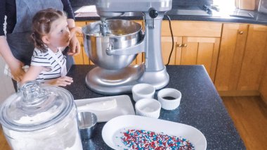 Adım adım. Anne ve kızı mutfakta şekerli kurabiye pişirme.