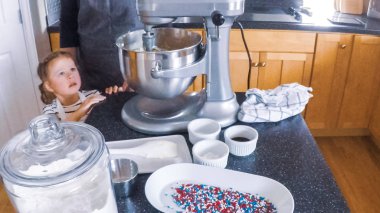 Adım adım. Anne ve kızı mutfakta şekerli kurabiye pişirme.