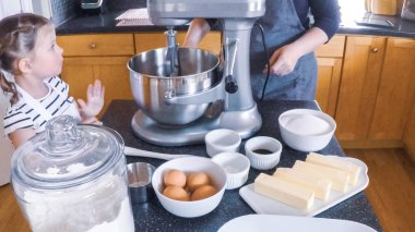 Adım adım. Anne ve kızı mutfakta şekerli kurabiye pişirme.