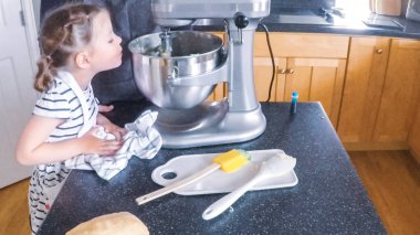 Adım adım. Anne ve kızı mutfakta şekerli kurabiye pişirme.