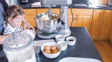 Adım adım. Anne ve kızı mutfakta şekerli kurabiye pişirme.