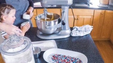 Adım adım. Anne ve kızı mutfakta şekerli kurabiye pişirme.