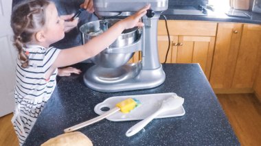 Adım adım. Anne ve kızı mutfakta şekerli kurabiye pişirme.