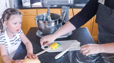 Adım adım. Anne ve kızı mutfakta şekerli kurabiye pişirme.