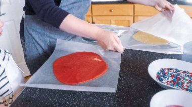 Adım adım. Anne ve kızı mutfakta şekerli kurabiye pişirme.