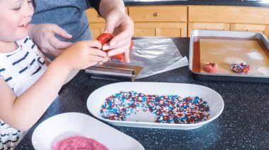 Adım adım. Anne ve kızı mutfakta şekerli kurabiye pişirme.