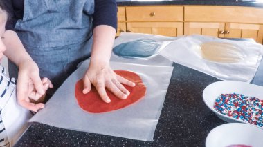 Adım adım. Anne ve kızı mutfakta şekerli kurabiye pişirme.