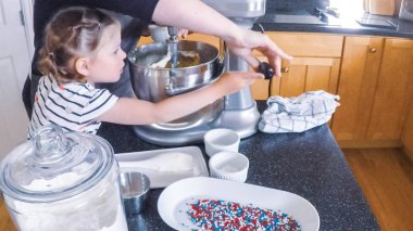 Adım adım. Anne ve kızı mutfakta şekerli kurabiye pişirme.