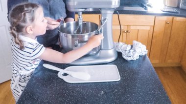 Adım adım. Anne ve kızı mutfakta şekerli kurabiye pişirme.