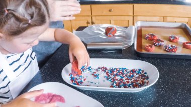 Adım adım. Anne ve kızı mutfakta şekerli kurabiye pişirme.