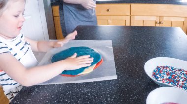 Adım adım. Anne ve kızı mutfakta şekerli kurabiye pişirme.