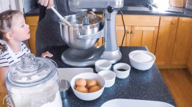 Adım adım. Anne ve kızı mutfakta şekerli kurabiye pişirme.