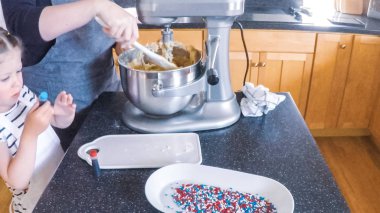 Adım adım. Anne ve kızı mutfakta şekerli kurabiye pişirme.