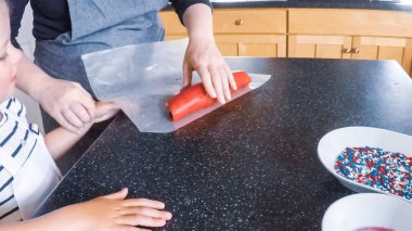 Adım adım. Anne ve kızı mutfakta şekerli kurabiye pişirme.